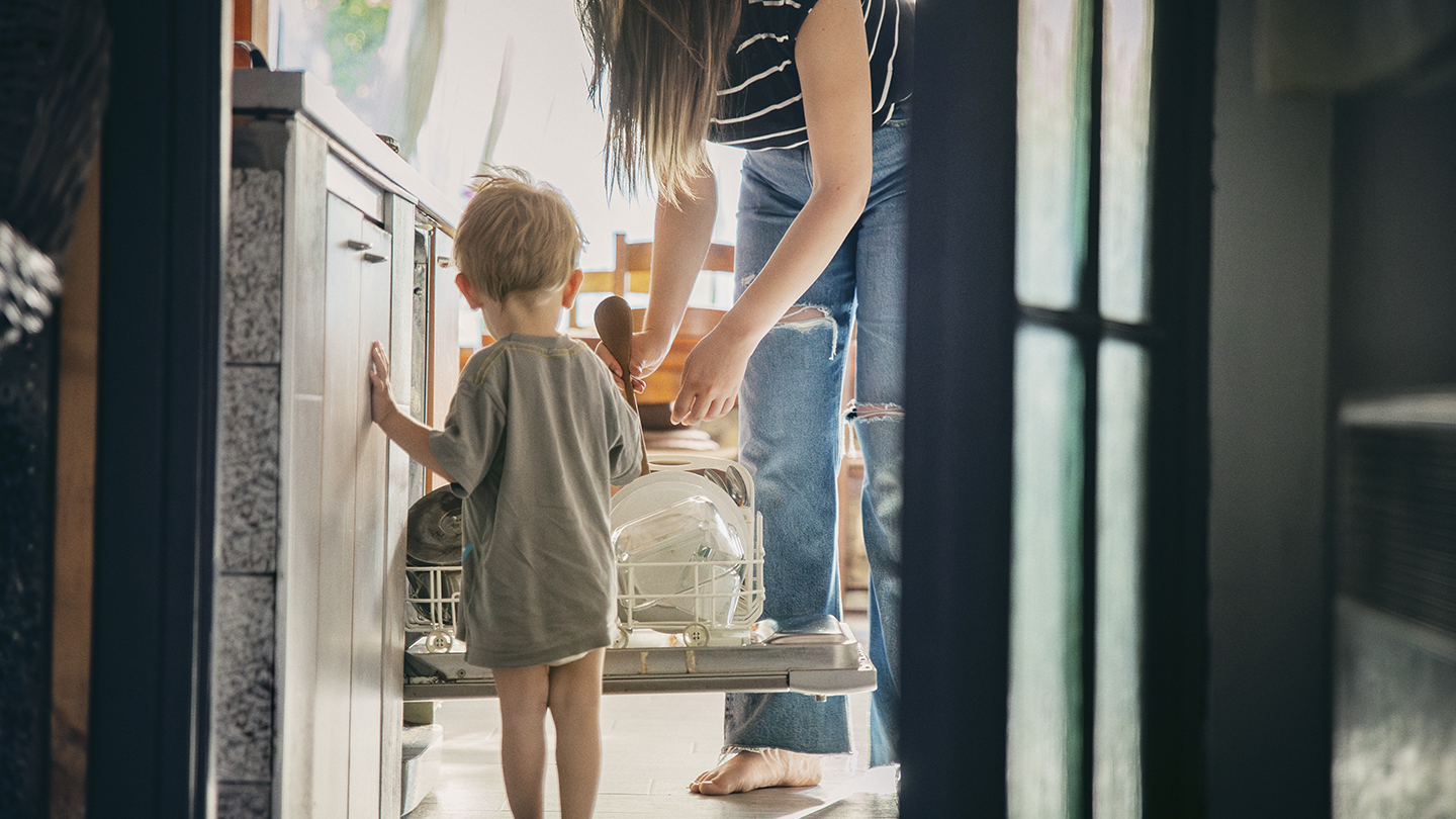 Lille dreng foran en opvaskermaskine