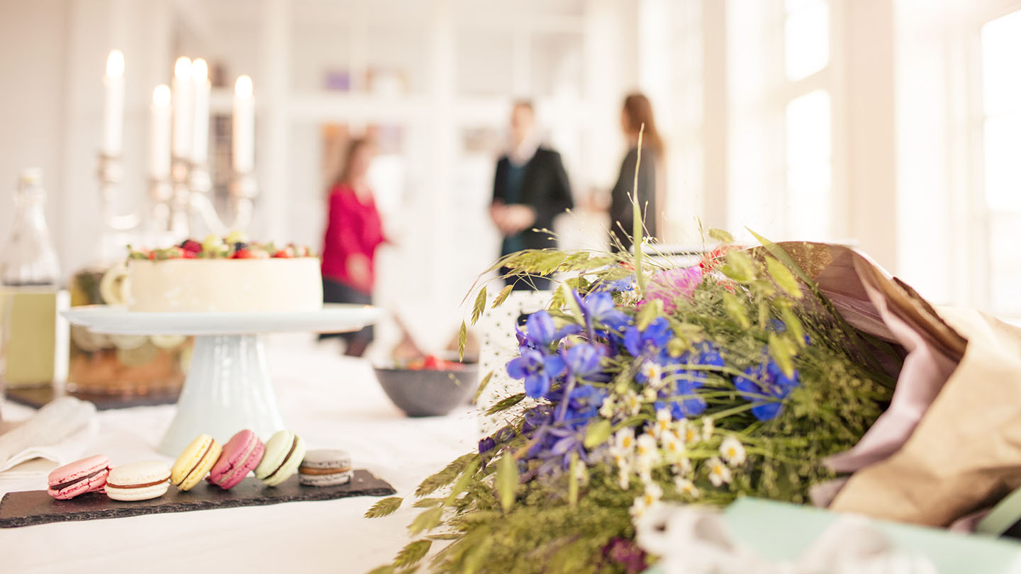 Cakes and flowers at a table.