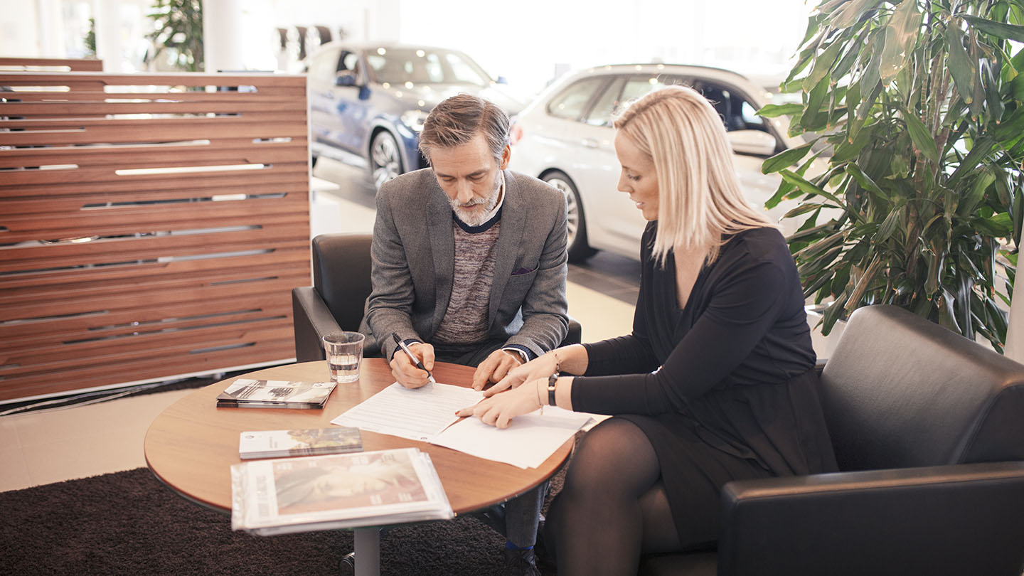 A man and woman are signing a document