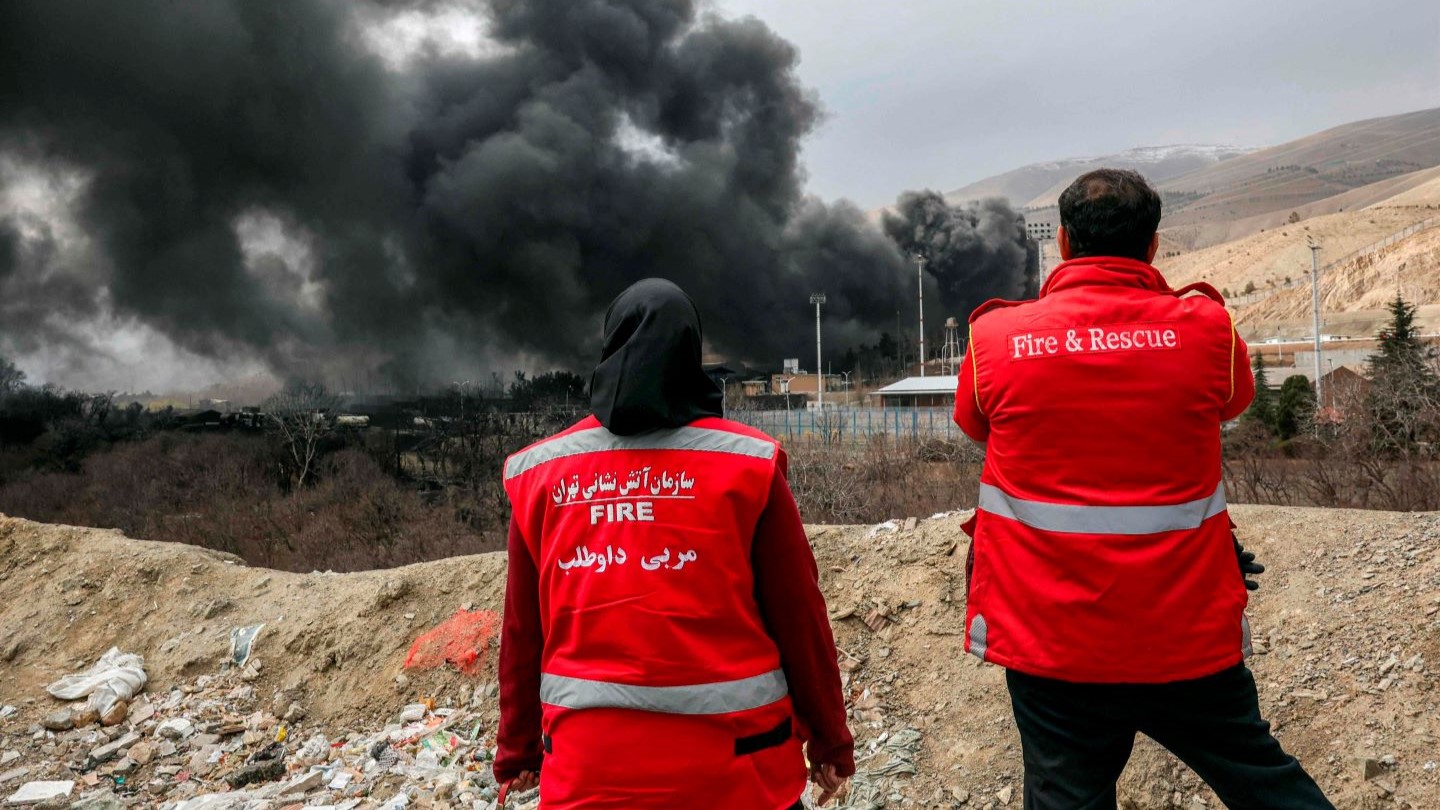 Young woman sitting by laptop in kitchen